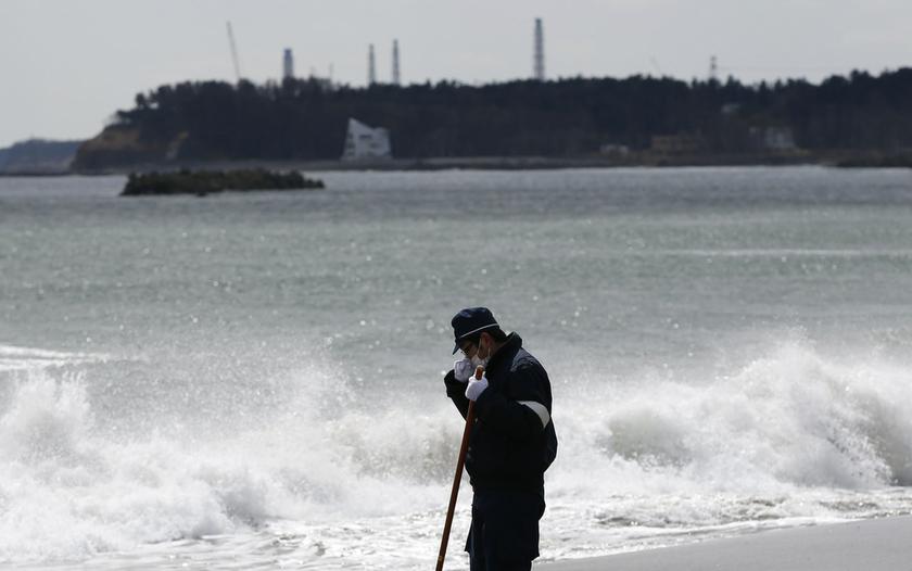 A police officer searches for missing people of the March 11, 2011 earthquake and tsunami along the coast side, Fukushima prefecture March 11, 2014.  u00e2u20acu201d Reuters pic