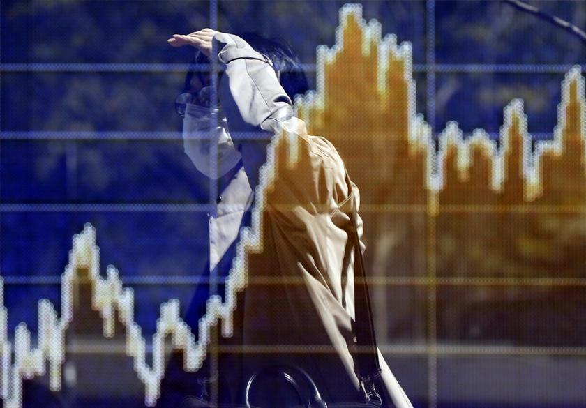 A man is reflected in a screen displaying a graph showing the movements of recent share averages outside a brokerage in Tokyo April 11, 2014. u00e2u20acu201d Reuters pic