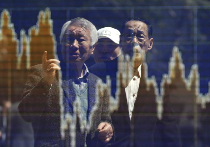 Men are reflected in a screen displaying a graph showing the movements of recent share averages outside a brokerage in Tokyo April 11, 2014. u00e2u20acu201d Reuters pic