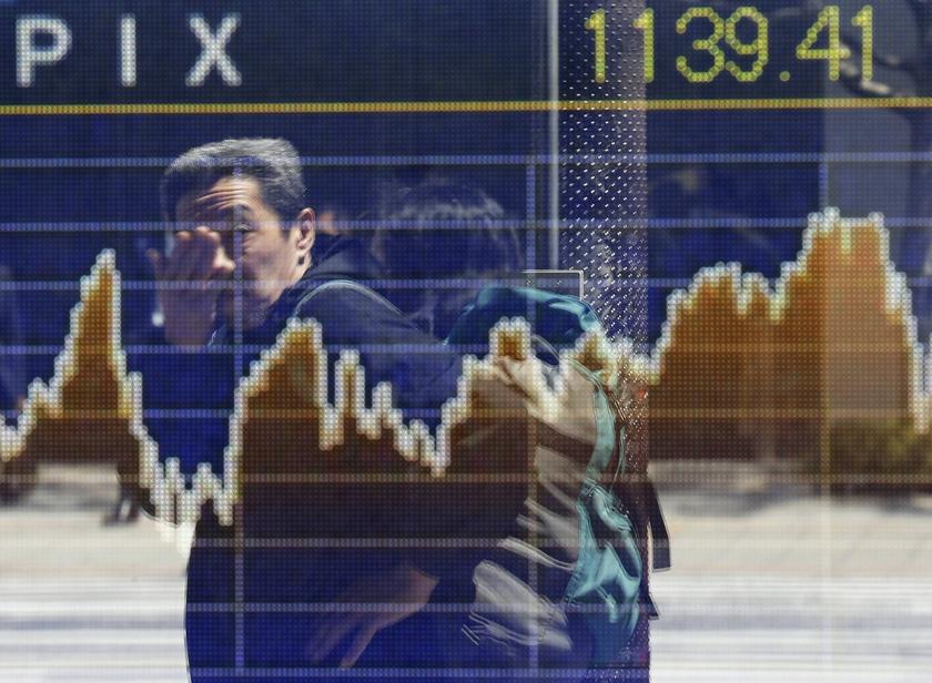 A man is reflected on a screen displaying a graph showing movements of the Tokyo Stock Exchange Stock Price Index (TOPIX), outside a brokerage in Tokyo April 14, 2014. u00e2u20acu201d Reuters picn