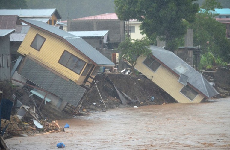 Flood waters run past damaged homes in the Solomon Islands' capital Honiara, April 5, 2014. u00e2u20acu2022 AFP pic