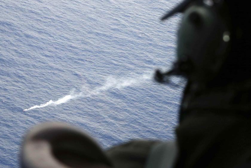 A crew member aboard a Royal New Zealand Air Force (RNZAF) P3 Orion maritime search aircraft watches a smoke flare after it was deployed to mark an unidentified object while flying over the southern Indian Ocean to look for the missing MH370 April 4, 2014