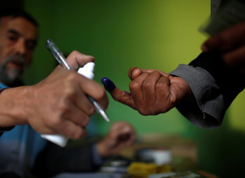 An Afghan election officer sprays invisible liquid on the finger of a voter at a polling station in Kabul April 5, 2014. u00e2u20acu201d Reuters pic