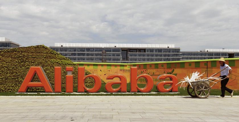 A worker walks past a logo of Alibaba Group at its headquarters on the outskirts of Hangzhou, Zhejiang province, August 24, 2013. u00e2u20acu201d Reuters/China Daily pic