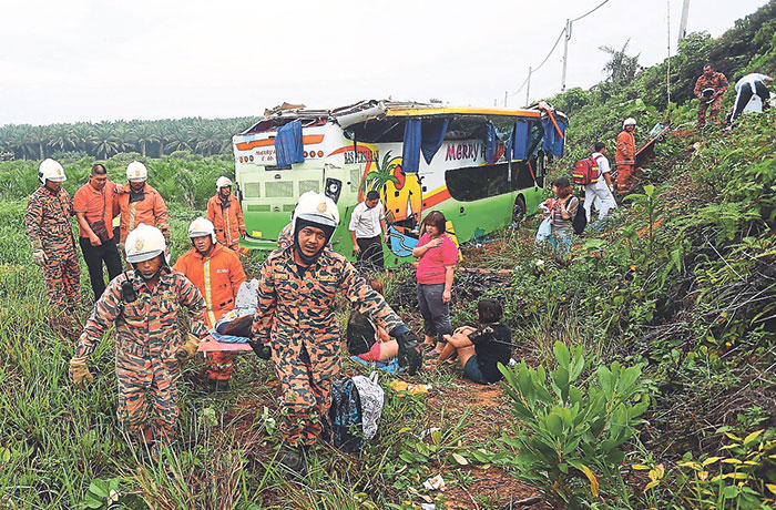 Fire and Rescue Department personnel helping passengers after a double-decker bus crashed into a ravine at Km70 of the Kuantan-Segamat highway near Pekan, Pahang, April 20, 2014. u00e2u20acu201d Malay Mail pic