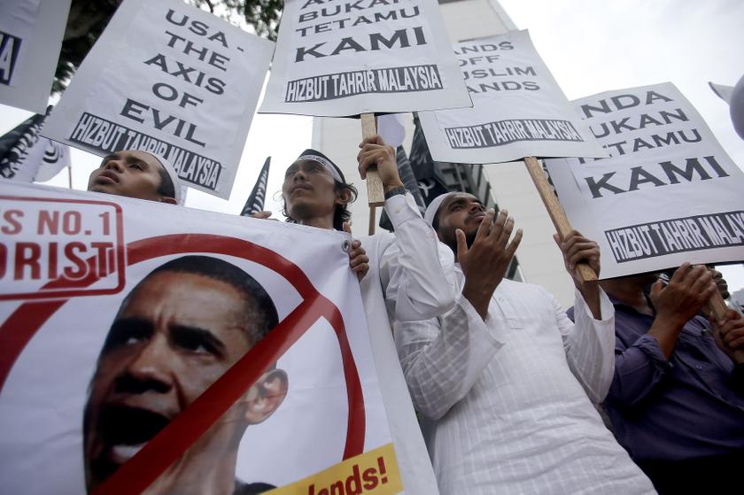 Supporters of the Hizbut Tahrir NGO pray while holding up placards against US President Barack Obama's planned visit to Malaysia next week, during a protest outside the US embassy in Kuala Lumpur April 18, 2014. u00e2u20acu201d Reuters pic