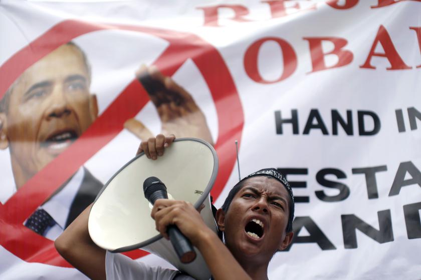 A supporter of the Hizbut Tahrir NGO holds a microphone to a loud-hailer as he shouts slogans against US President Barack Obama's planned visit to Malaysia next week, outside the US embassy in Kuala Lumpur, April 18, 2014. u00e2u20acu201d Reuters pic