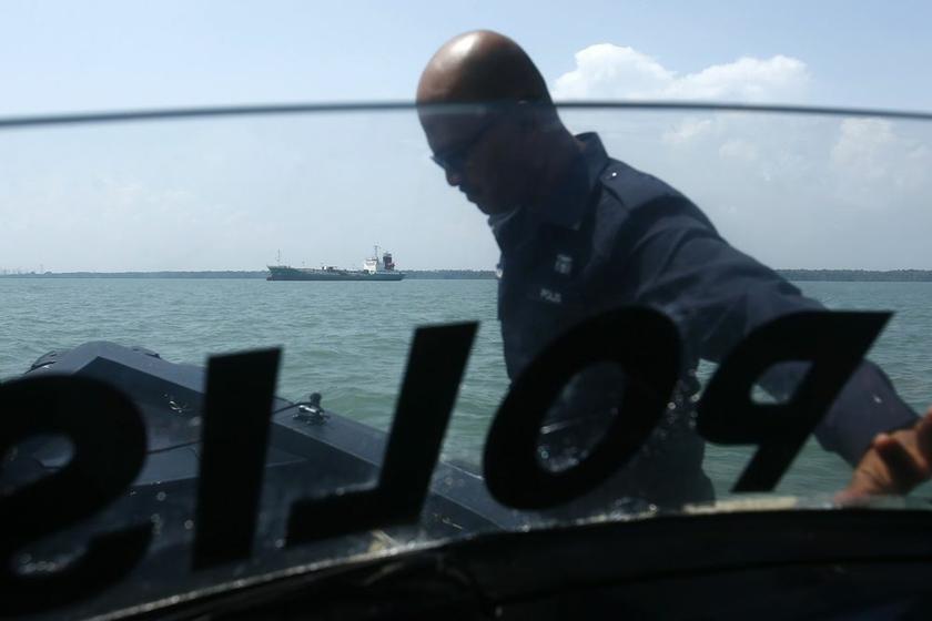 A maritime police is seen as the Japanese oil tanker which was raided by armed pirates sails in the background at Port Klang, outside Kuala Lumpur April 23, 2014. u00e2u20acu2022 Reuters pic