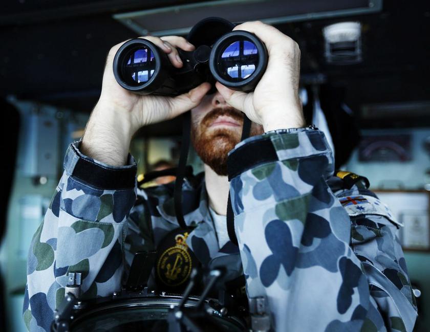 Maritime Warfare Officer, Sub Lieutenant Officer Archibald, looks through binoculars on Australian Navy ship HMAS Perth in southern Indian Ocean, during search for missing Malaysian Airlines flight MH370. u00e2u20acu2022 Reuters pic