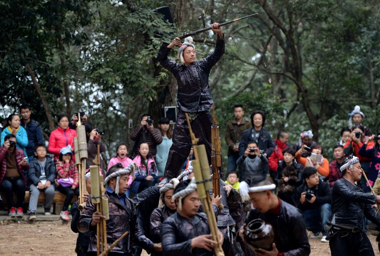 This photo taken on February 4, 2014 shows members of the Miao minority group performing for tourists with their guns in Biasha Village, Guizhou Province. u00e2u20acu201d AFP pic