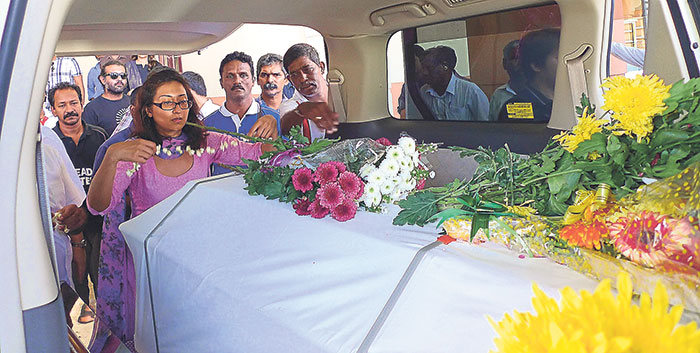 Sangeet placing flowers on Michael Corneliusu00e2u20acu2122s coffin. u00e2u20acu201d Picture by Marcus Pheong