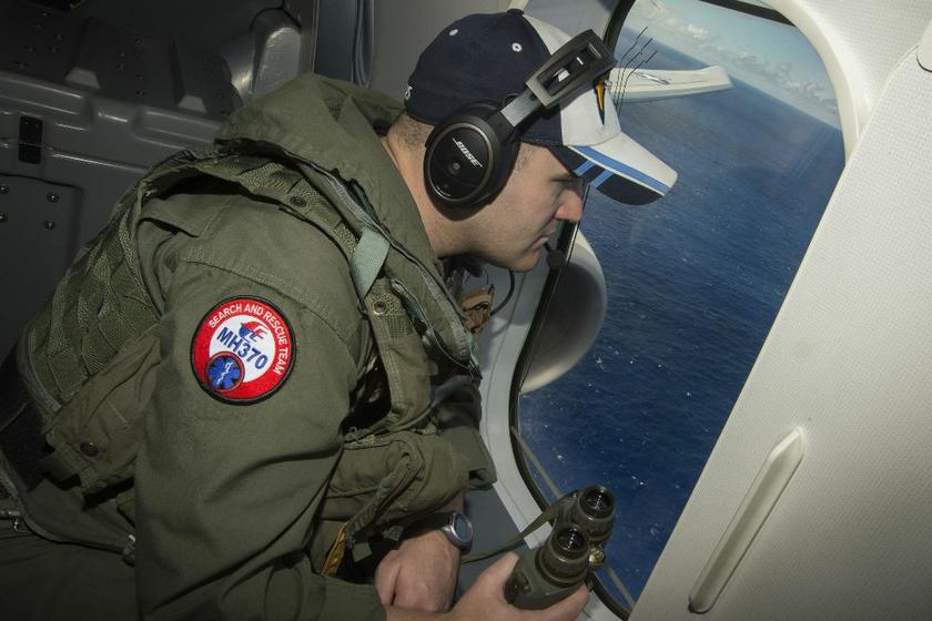 Naval Aircrewman 2nd Class Karl Shinn looks out a window of a P-8A Poseidon while flying over the Indian Ocean during a search mission to locate Malaysia Airlines flight MH370, in this US Navy handout photo taken April 10, 2014. u00e2u20acu2022 Reuters pic