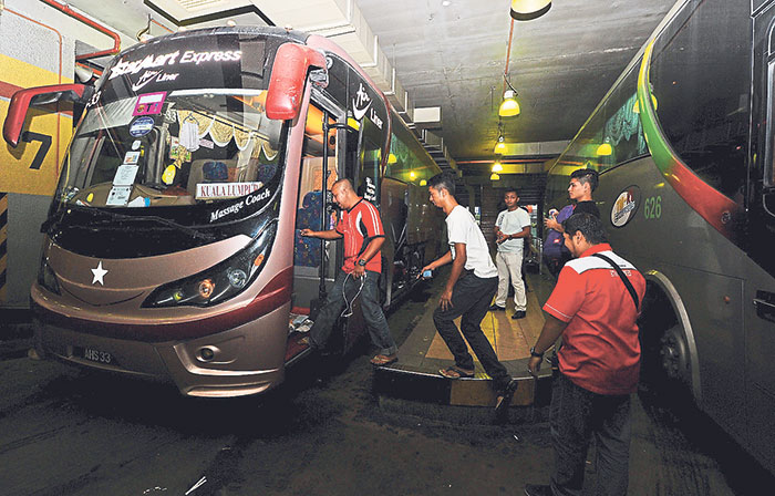 Passengers board a bus at Pudu Sentral, April 23, 2014. The Transport Ministry is enforcing new guidelines to make express bus travel safer. u00e2u20acu201d Picture by Zuraneeza Zulkifli