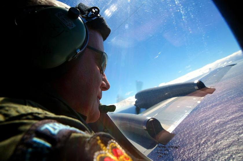 Seargent Trent Wyatt looks out an observation window aboard a Royal New Zealand Air Force (RNZAF) P3 Orion maritime search aircraft as it flies over the southern Indian Ocean looking for debris from missing Malaysian Airlines flight MH370 April 11, 2014. 