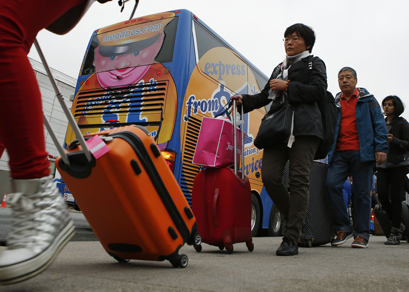 Passengers line up to board a Megabus bus in New York City May 8, 2014. u00e2u20acu201d Reuters pic