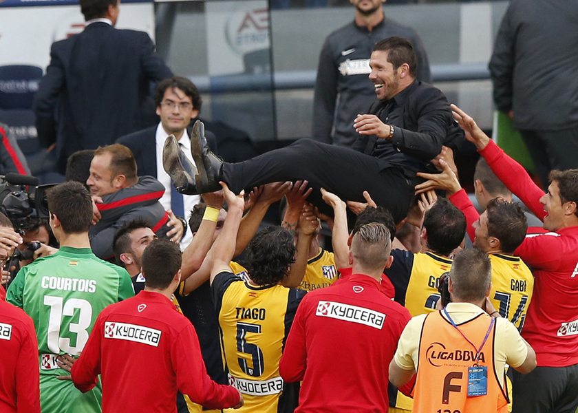 Atletico Madrid's players carry their coach Diego Pablo Simeone after the team won their Spanish First Division match against Barcelona at Nou Camp stadium in Barcelona, May 17, 2014. u00e2u20acu201d Reuters pic
