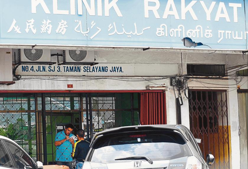 A man in the clinic records details of a member of the public seeking an MC on May 7, 2014. u00e2u20acu201d Picture by The Malay Mail