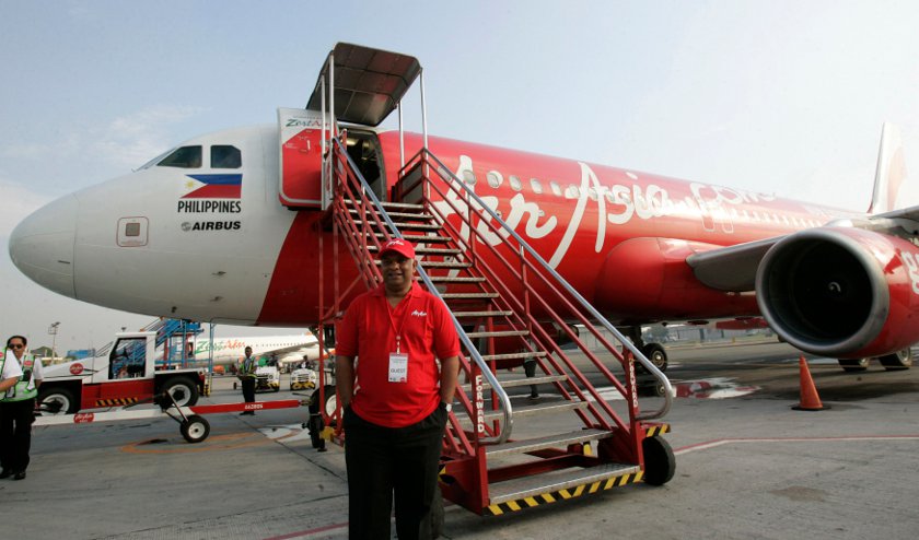 Tony Fernandes, CEO of AirAsia, poses in front of an AirAsia Airbus A320 before boarding at the domestic airport in Manila May 23, 2014. u00e2u20acu201d Reuters pic