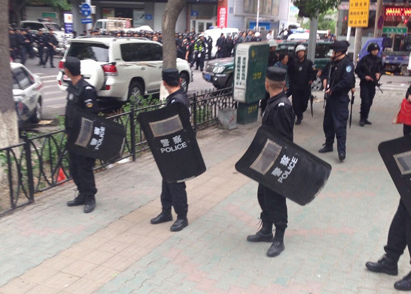 Riot policemen look behind them toward the site of an explosion, which has been cordoned off, as they stand guard in downtown Urumqi, Xinjiang Uighur Autonomous Region, May 22, 2014. u00e2u20acu201d Reuters pic