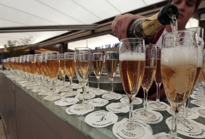 A man pours champagne into a glass at a private beach bar along La Croisette during the 66th Cannes Film Festival in Cannes May 17, 2013. u00e2u20acu201d Reuters pic