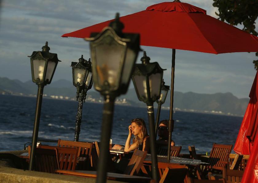 A woman at a restaurant at the fort of Copacabana beach in Rio de Janeiro April 29, 2014; grin and bear the tourist costs of visiting Brazil for the World Cup Reuters