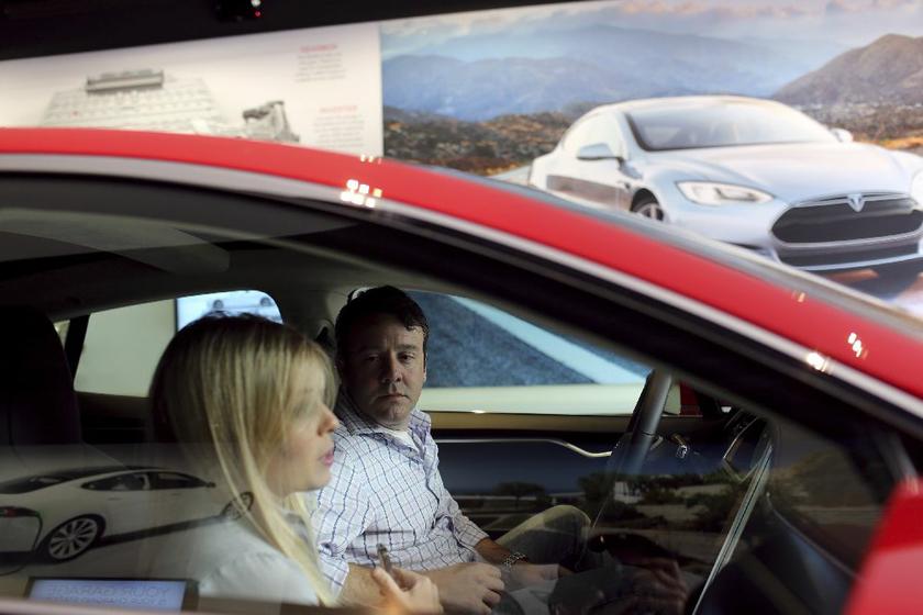 Jason Middleton and Alexis Georgeson in a Tesla Model S in the showroom at a Tesla Motors dealership in Corte Madera Village, an outdoor retail mall, in Corte Madera, California May 8, 2014 Reuters