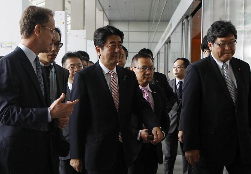 Japan's Prime Minister Shinzo Abe (C) listens to Marina Bay Sands (MBS) casino and resort Chief Executive Officer George Tanasijevich (L) as he visits the MBS Skypark in Singapore May 30, 2014 Reuters