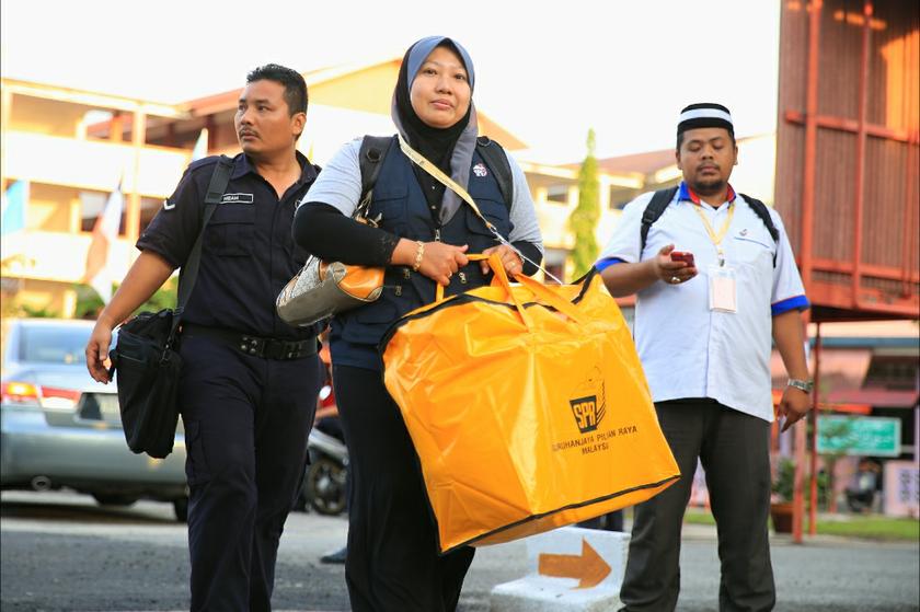An EC official carries the ballot papers. — Picture by Saw Siow Feng