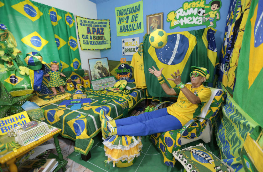 Brazilian soccer fan Marilza Guimaraes da Silva, 63, plays with a ball as she poses for picture, dressed in one of her many outfits matching the colors of the Brazil's national flag (green, yellow, white and blue) at her home in Brasilia May 27, 2014. u00e2u20acu201d