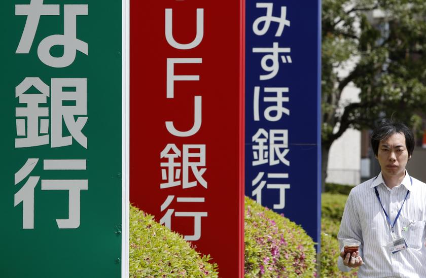 A pedestrian walks past signboards of Resona Bank (left), Bank of Tokyo-Mitsubishi UFJ (centre) and Mizuho Bank in Tokyo May 14, 2014. u00e2u20acu201d Reuters pic 