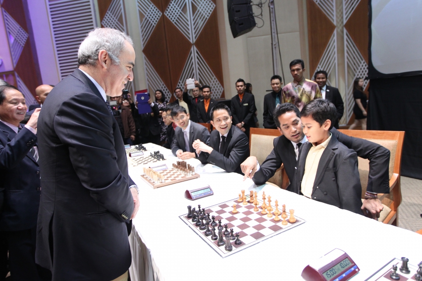 Kasparov at the Charity Simultaneous Exhibition with Khairy Jamaluddin helping a young talent.