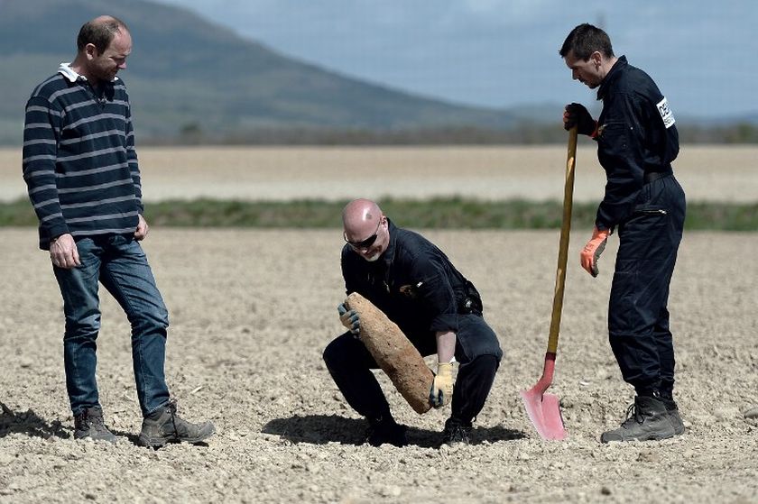 A mine clearance expert of the civil safety lifts a unexploded shell dating from World War I found in an agricultural field on April 9, 2014 in Aspach-le Bas, eastern France. u00e2u20acu201d AFP pic