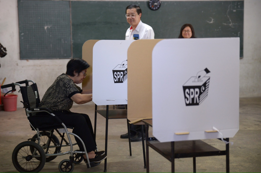 Penang Chief Minister Lim Guan Eng looks on as his mother marks her ballot at SMJK Chung Hwa in Greenlane, Penang, on May 25, 2014. u00e2u20acu201d Picture by K.E. Ooin
