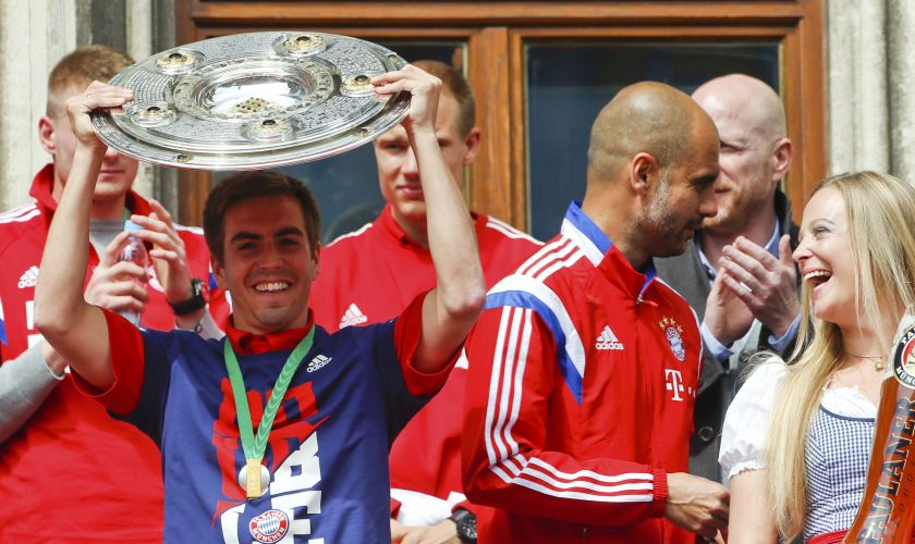 Bayern Munich's Philipp Lahm holds up the Bundesliga trophy next to coach Pep Guardiola at the balcony of the town hall during celebrations after their German Cup final against Borussia Dortmund, in central Munich, May 18, 2014. u00e2u20acu2022 Reuters pic