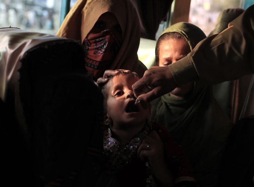 A polio worker administers polio vaccine to a girl as she sits in her mother's lap in a bus during a vaccination campaign at a bus stop in Rawalpindi May 13, 2014. u00e2u20acu201d Reuters pic 