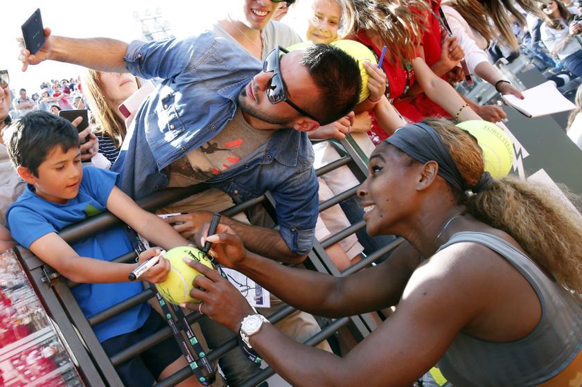 Serena Williams poses for a selfie with a supporter as she signs on a ball, after winning the women's singles final match against Sara Errani of Italy, at the Rome Masters tennis tournament May 18, 2014. u00e2u20acu201du00c2u00a0Reuters pic