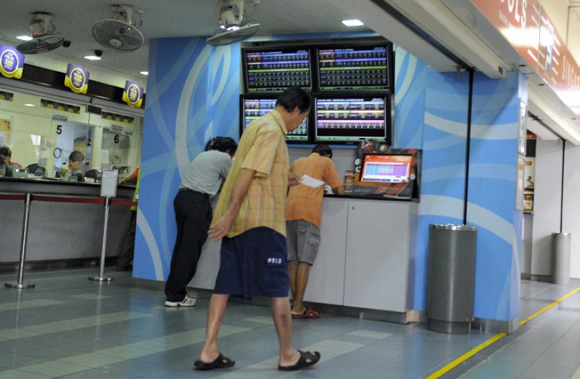 File photo shows a man walking out of a legal betting shop in Singapore. Police said they have arrested 18 people believed to be part of a multi-million dollar illegal football betting ring ahead of the World Cup. u00e2u20acu201d AFP pic