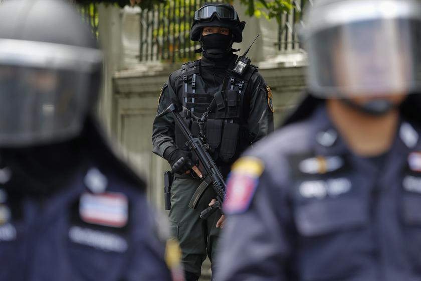A masked and armed member of special forces stands behind riot policemen providing security near an army centre in Bangkok May 23, 2014. u00e2u20acu201d Reuters pic
