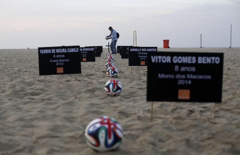 A demonstrator sets an official 2014 World Cup football next to a cross during a protest against deaths and children injured during police operations in Rio de Janeiro slums, at Copacabana beach in Rio de Janeiro May 7, 2014. u00e2u20acu201d Reuters pic