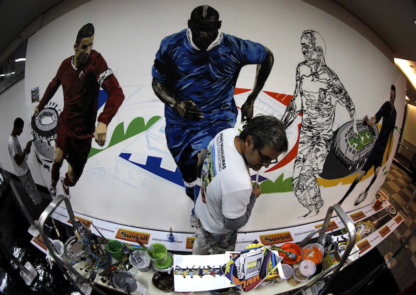 Brazilian artist Paulo Consentino works on a mural in celebration of the 2014 World Cup at Congonhas airport in Sao Paulo May 25, 2014.u00c2u00a0u00e2u20acu201d Reuters pic