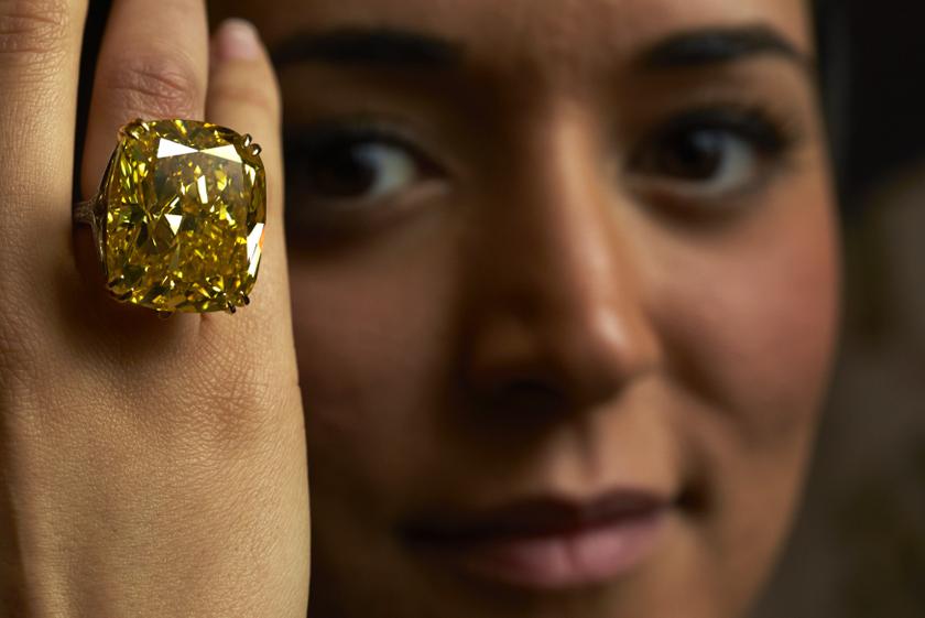 A model poses with a vivid yellow 100.09 carats diamond during an auction preview at Sothebyu00e2u20acu2122s in Geneva May 7, 2014. u00e2u20acu201d Reuters pic