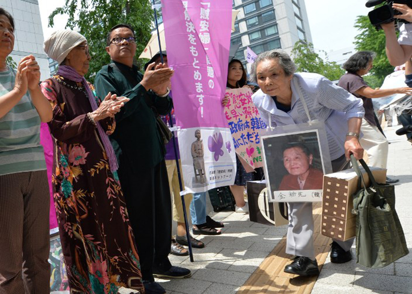Former u00e2u20acu02dccomfort womenu00e2u20acu2122 and their relatives gather to stage a standing demonstration near the Diet in Tokyo on June 2, 2014 to demand that Japan formally atone for forcing women into sexual slavery in its wartime military brothels. u00e2u20acu201d AFP pic