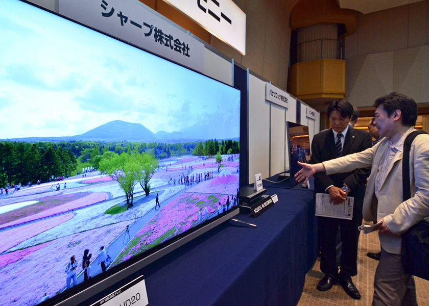 Visitors look at Japanese electronics maker Sharp's new 4K television and newly developed 4K capable tuner, demonstrated at the launch ceremony of the next generation of 4K high-definition broadcasting in Tokyo on June 2, 2014. u00e2u20acu201d AFP pic