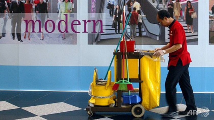 A cleaner pushes his trolley in a shopping centre in Singapore. u00e2u20acu201d AFP pic