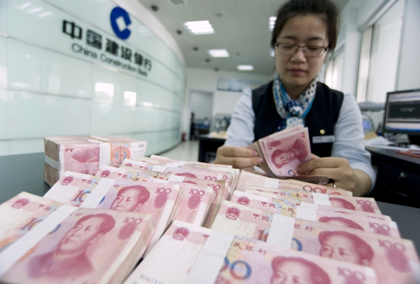 A clerk counts Chinese 100 yuan banknotes at a branch of China Construction Bank in Hai'an, Jiangsu province June 10, 2014. u00e2u20acu201d Reuters pic
