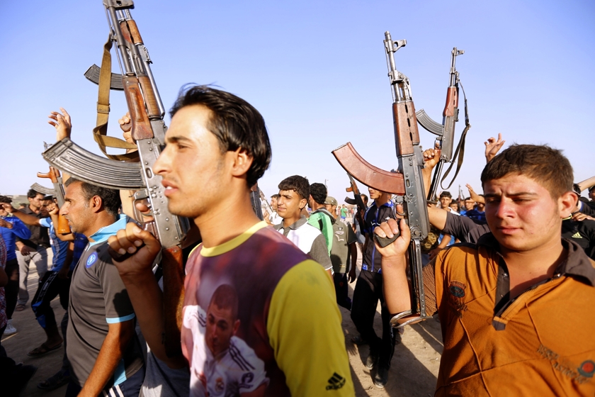 Volunteers, who have joined the Iraqi Army to fight against predominantly Sunni militants from the radical Islamic State of Iraq and the Levant (ISIL), carry weapons during a parade in the streets in Al-Fdhiliya district, eastern Baghdad June 15, 2014. u00e2u20ac