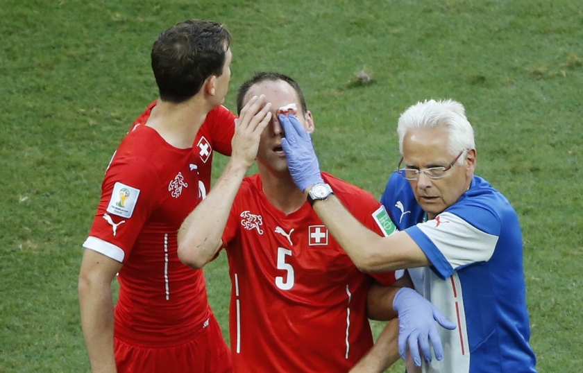 Switzerland's Steve von Bergen (centre) is helped off the pitch by a medic next to teammate Stephan Lichtsteiner during their 2014 World Cup Group E football match against France at the Fonte Nova arena in Salvador June 20, 2014. u00e2u20acu201d Reuters pic