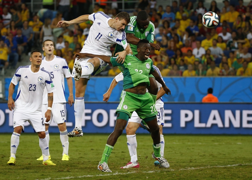 Bosnia's Edin Dzeko heads the ball next to Nigeria's Kenneth Omeruo (22) and Shola Ameobi as he misses a chance to score a goal during their 2014 World Cup Group F football match at the Pantanal arena in Cuiaba June 22, 2014. u00e2u20acu201d Reuters pic