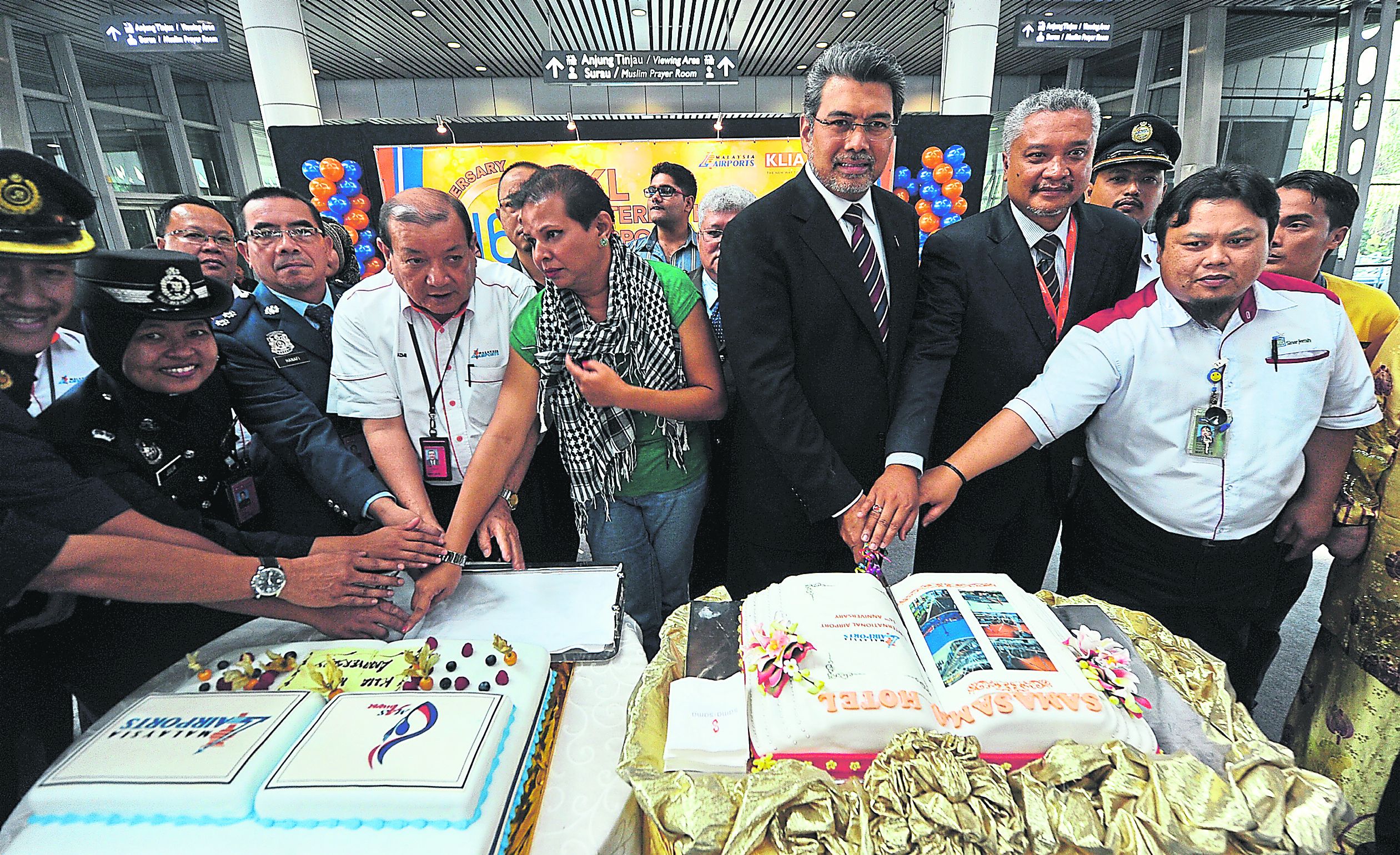 Badlisham (third from right) celebrates KLIAu00e2u20acu2122s 16th anniversary by cutting a cake with fellow airport staff. u00e2u20acu201d Picture by Zuraneeza Zulkifli
