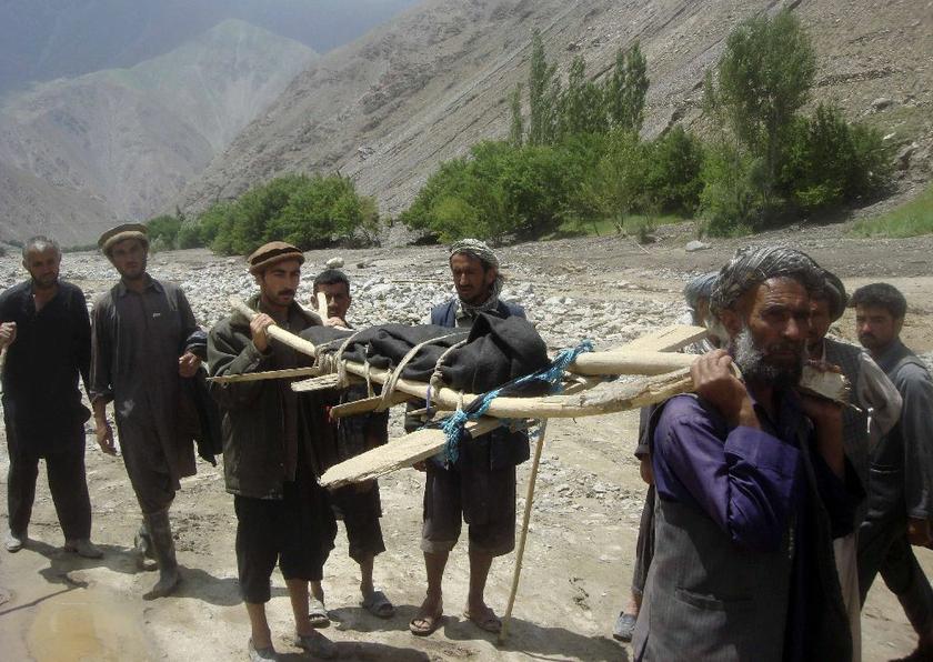 Villagers carry a victim after floods in the Gozargah-e Noor district of Baghlan province June 7, 2014. At least 58 dead Reuters